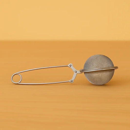 Pince à thé TeaClic en acier inoxydable – vue de face posée à plat